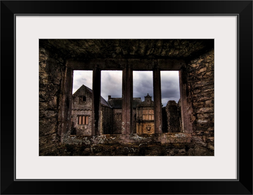 View through a stone window of ruined castle. Beaupre Castle medieval ruins in Wales.