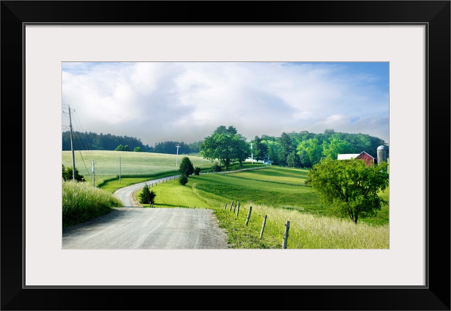 Photograph of a countryside road heading towards a red barn on the right.