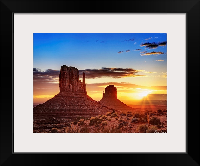 Landscape photograph of the buttes at Monument Valley in Arizona with a bright sunset in the background.