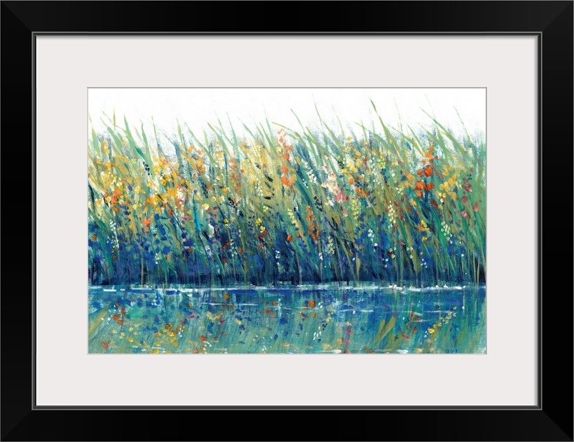 A mass of grasses and reeds interspersed with wild flowers on the edge of a lake or pond; the flowers are reflected in the...