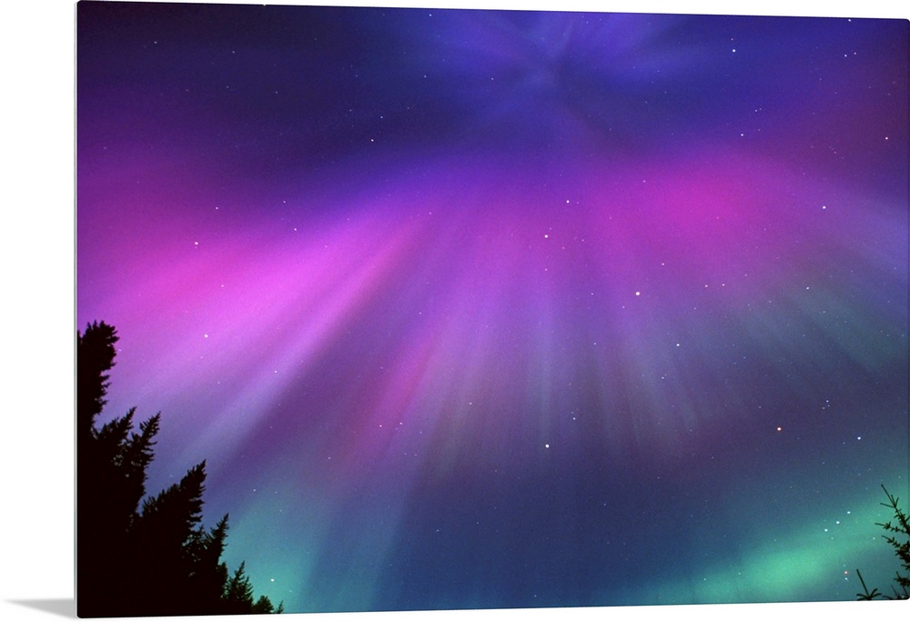 This landscape photograph captures the glow of the Northern lights and the speckles of stars beyond it.