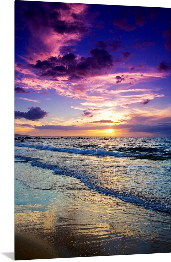 Large photograph displays the waves of the Pacific Ocean slowly coming into shore and crashing against the sandy beach of ...