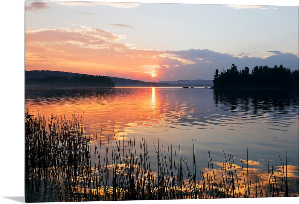 Canvas print of a peaceful lake with a sunset reflected onto it.