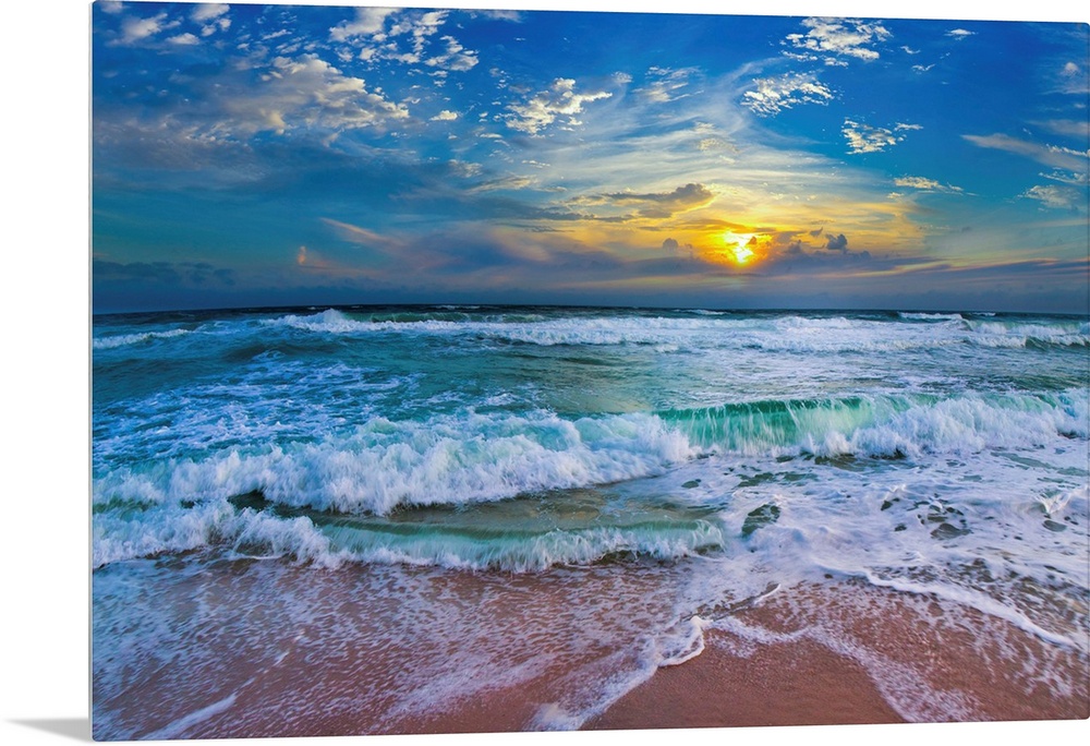 A glimpse of a yellow sunset within a cold blue sunset. Blue waves hit a tropical sea shore.