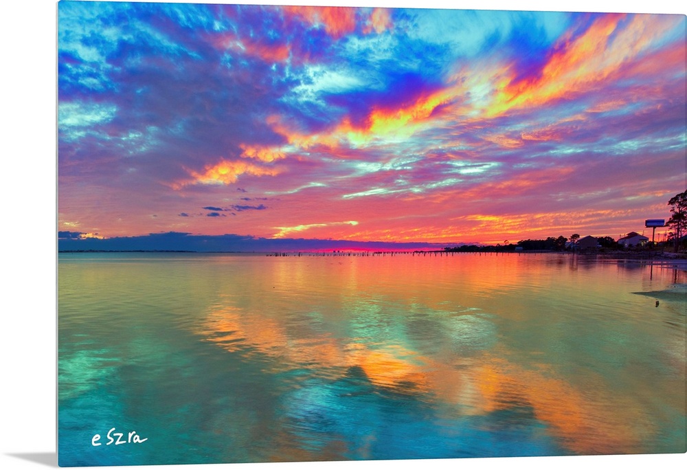 Cloud streaks reflected in this pink sunset over the sea.