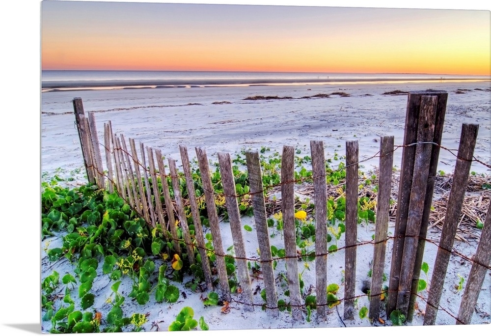 Wall art for the home or office this landscape photograph is of a battered barrier fence ends on the edge of the sandy sho...