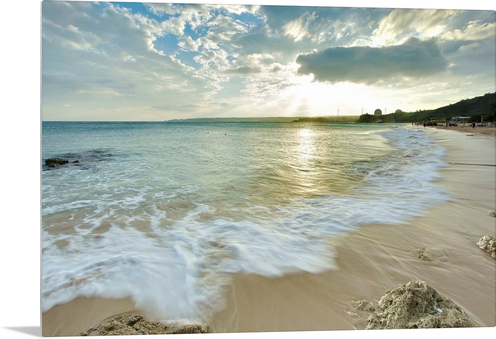 Nanwan, Kenting on  cloudy afternoon with foaming green sea water rushing in onto sandy beach with coral reefs and strong ...