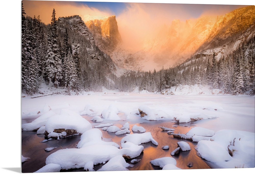 Giant photograph of a snow covered landscape filled with trees surrounding and a frozen river running down the center of t...