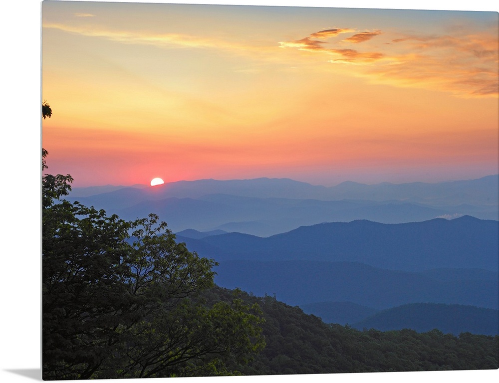 Photo of the sun setting over the mountains from the Blue Ridge Parkway in North Carolina.