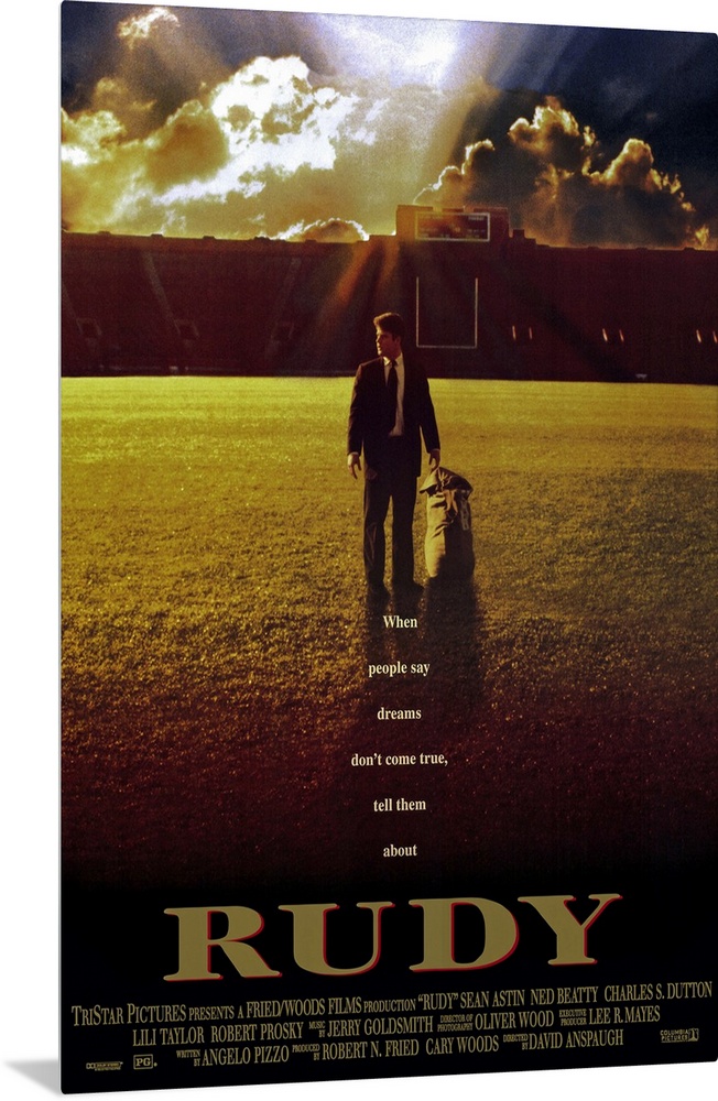 This large vertical piece is a movie poster for "Rudy". It pictures the star character walking across the football field i...