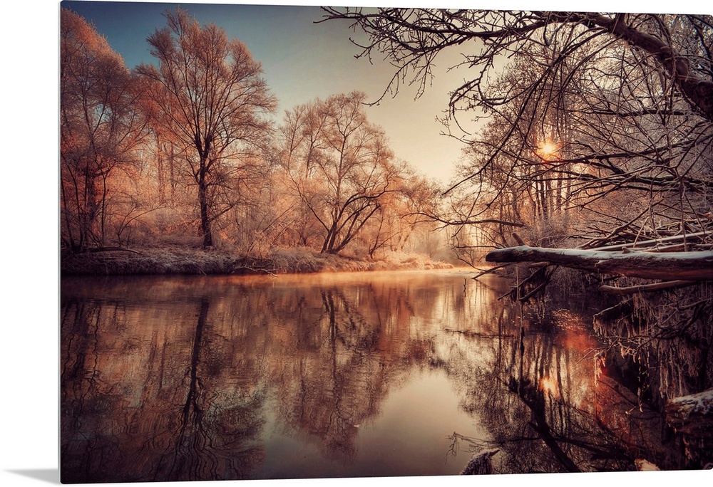 In this landscape photograph morning light reflects off a river in a forest covered with the first frost.