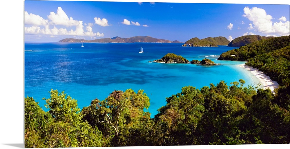 Panoramic photograph of cove with water on left and tree lined beach on right.  There are vegetation covered mountains in ...