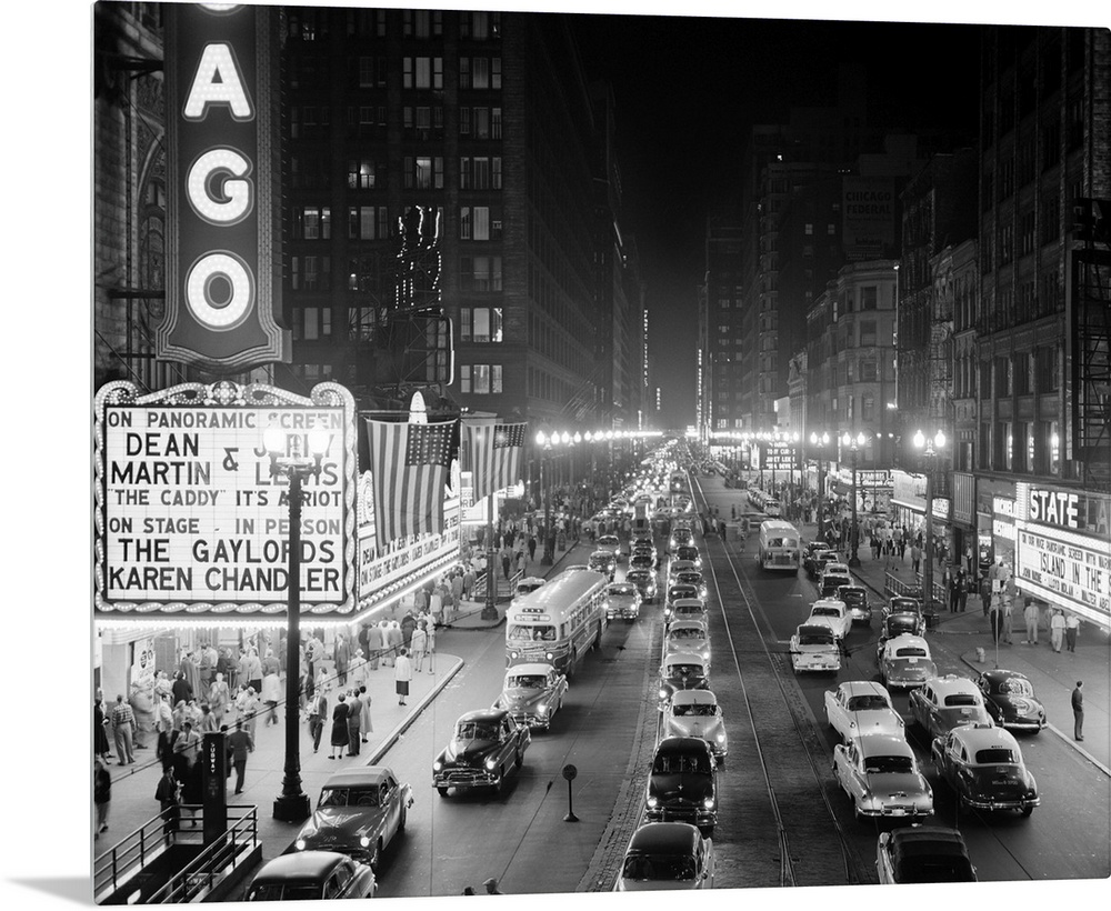 1950's 1953 Night Scene Of Chicago State Street With Traffic And Movie Marquee With Pedestrians On The Sidewalks.