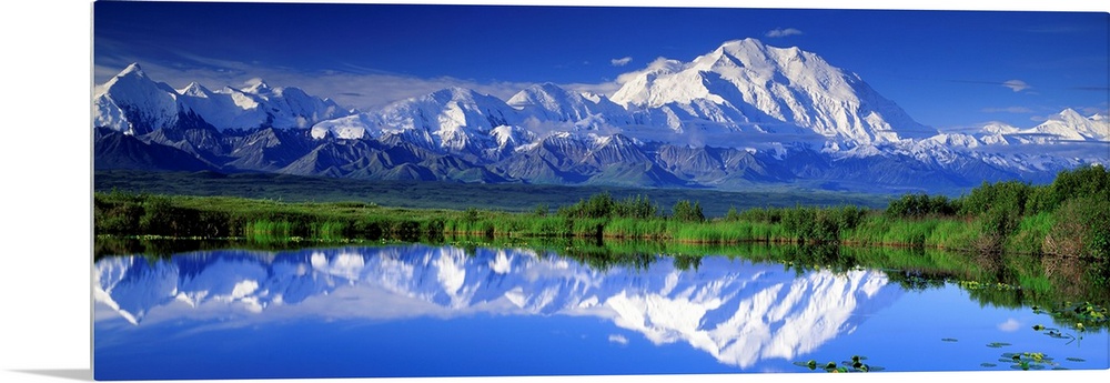 Panoramic view of snowcapped mountains and Mt. McKinley reflecting in still waters.