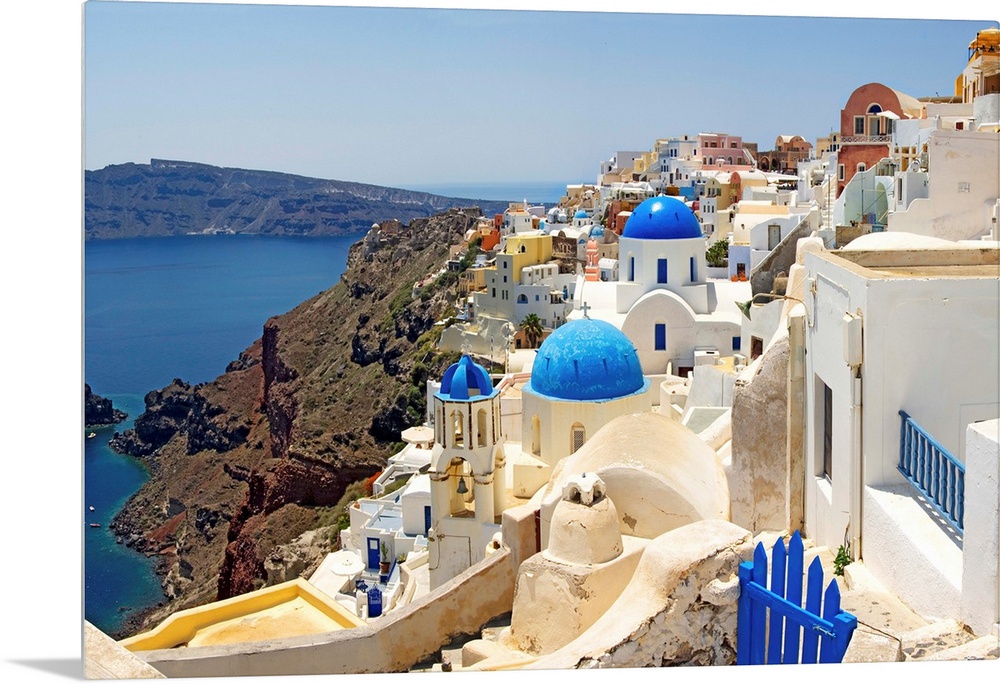 This hillside city with its famous colored roof tops overlooks a rocky Grecian sea in this panoramic photograph.