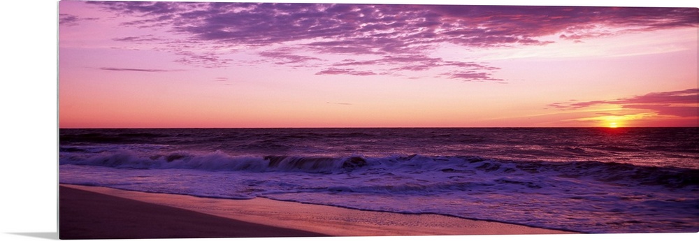 Small waves washing up on shore as the sunrises in this landscape photograph.