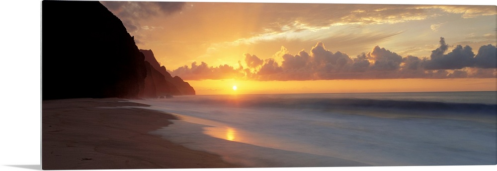 The sun sinks below the horizon viewed from the beach on a tropical Pacific island.