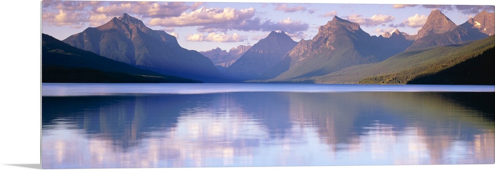 Oversized, horizontal photograph of mountains reflecting in the calm waters of Lake McDonald in Glacier National Park, Mon...