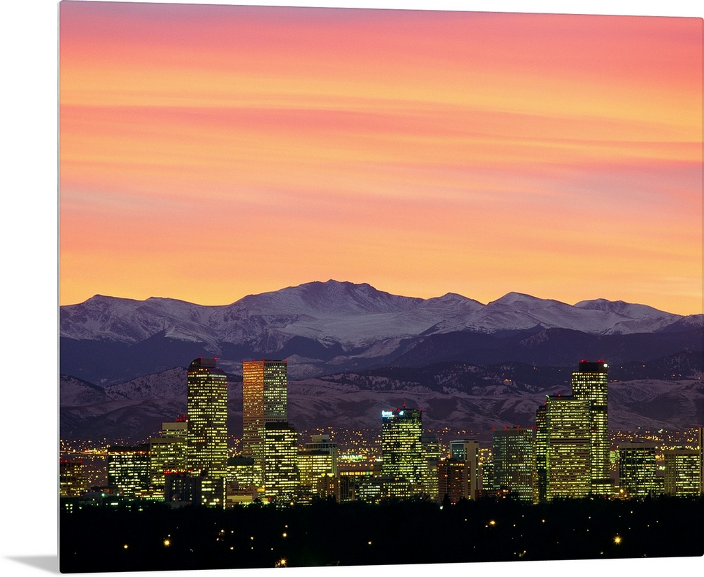 Large photograph taken of the Denver, Colorado skyline at dusk.  The snow covered mountains in the background provide a gr...