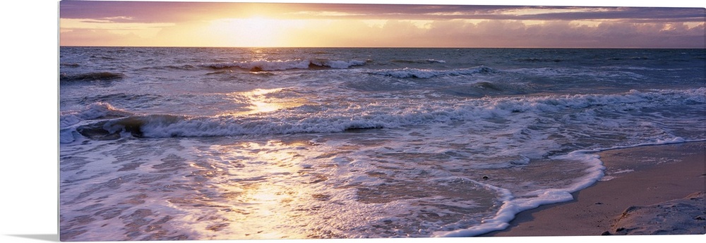 Panoramic photograph of a sunset on a sandy beach in the Gulf of Mexico located within Florida.  The bright light of the s...