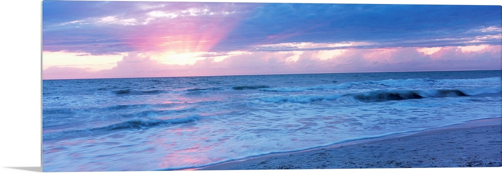 Large panoramic photo of the sun setting over a beach in Naples, Florida (FL).