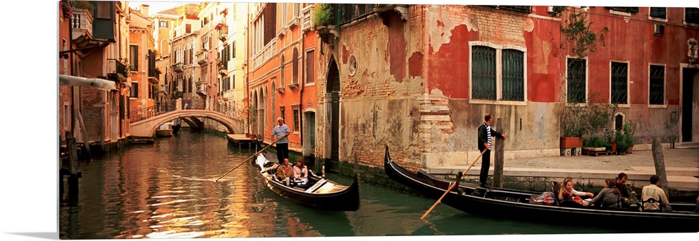 Gondolas paddling through canals lined with historic Venetian buildings.