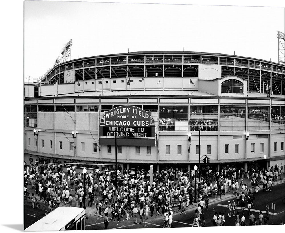 A black and white photograph taken outside of the Chicago Cubs stadium as fans are shown entering for the first game of th...