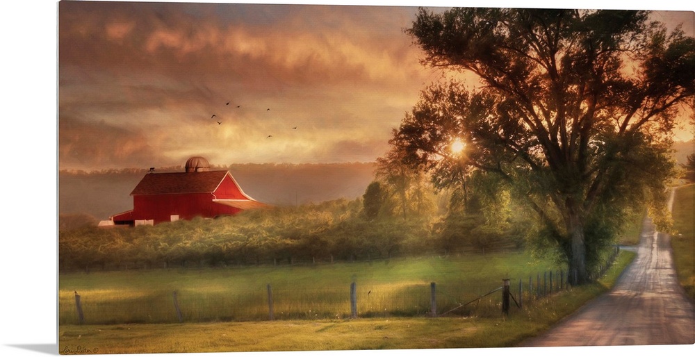 A dirt road in the countryside with a red barn in the distance at sunset.