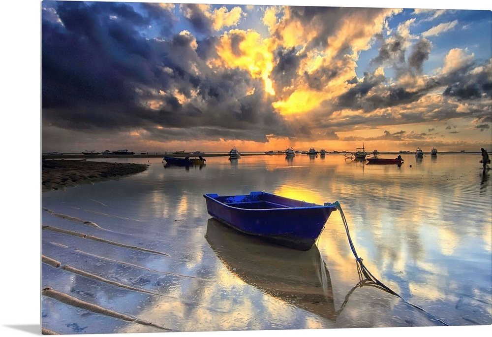 A blue boat docked in shallow water at sunrise, Semawang Beach, Bali.