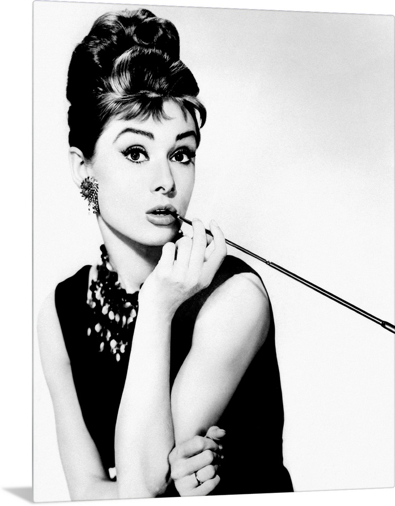 This wall art is a portrait photograph of the Hollywood Icon character Holly Golightly in her signature black dress, jewel...
