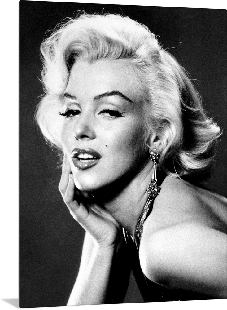 Large, portrait, black and white photograph of Marilyn Monroe, leaning forward with her palm on her face.