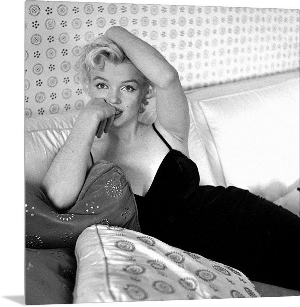 Wall art of Marilyn Monroe sitting on a sofa looking at the camera.