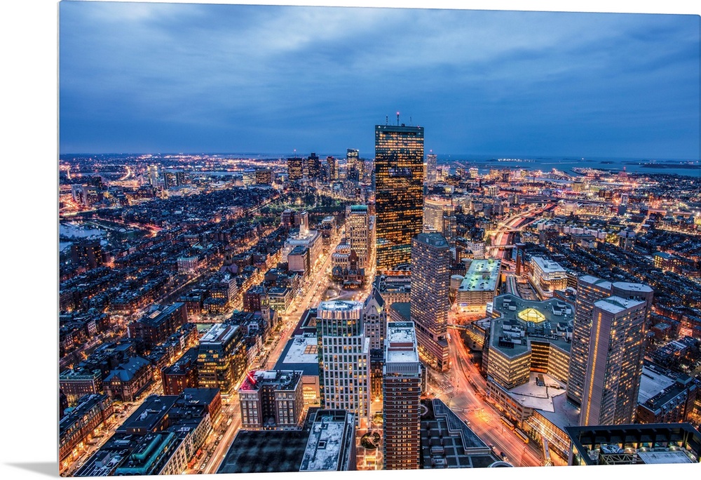 View from a skyscraper of tall buildings in Boston glowing at night.
