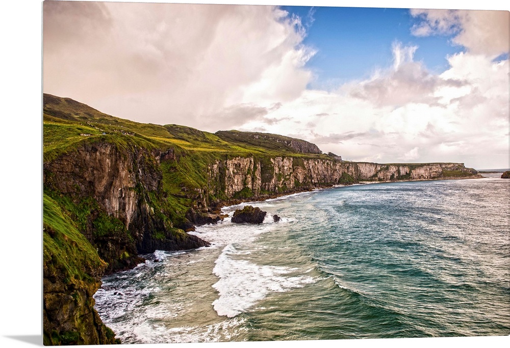 Landscape photograph of the picturesque Cliffs of Moher with a cloudy sky above, located at the southwestern edge of the B...