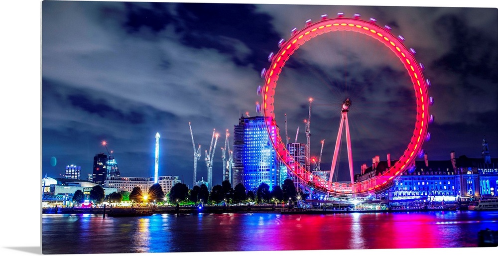 View of the brightly colored ferris wheel at night in London, England.