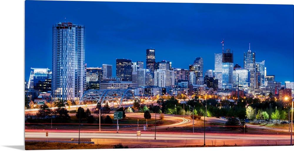 Photo of Denver's skyline at night with light trails.