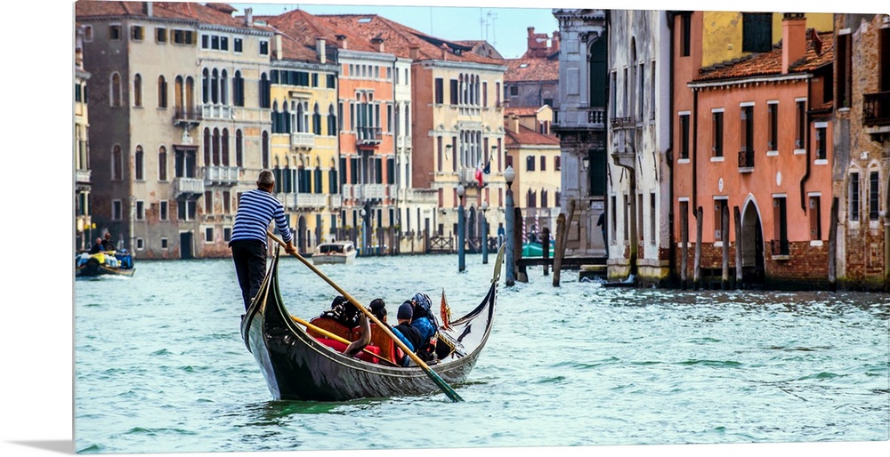 Photograph of the rear side of a gondola rowing through Grand Canal in Venice.