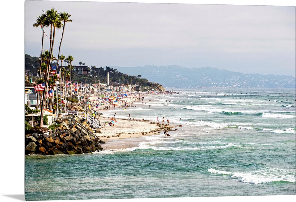 Landscape photograph of the La Jolla coast filled with beach goers and palm trees.