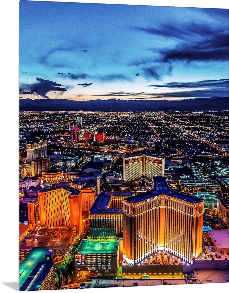 Aerial view of the Las Vegas Strip illuminated in the early evening with cloudy skies.