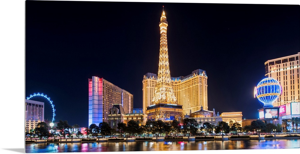 Panoramic photograph of the Las Vegas Strip lit up at night highlighting the Eiffel Tower Restaurant, hot air balloon, and...