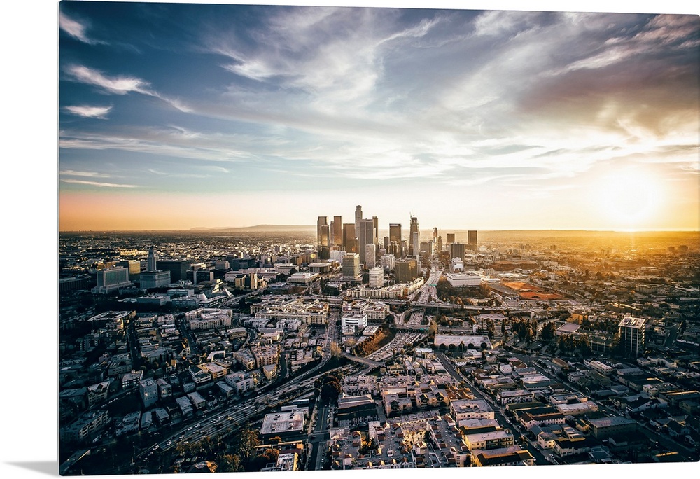 The setting sun visible behind the skyscrapers in the Los Angeles skyline, California.