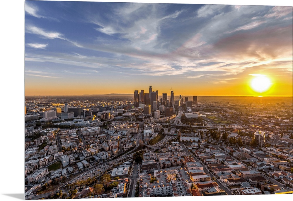 The setting sun visible behind the skyscrapers in the Los Angeles skyline, California.