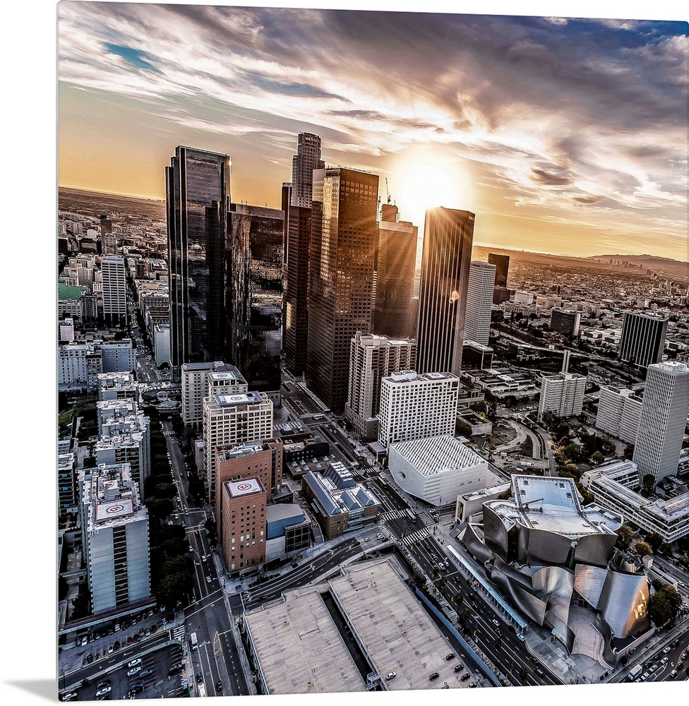 The setting sun visible behind the skyscrapers in the Los Angeles skyline, California.