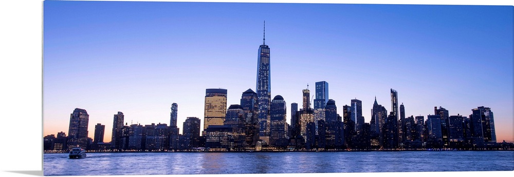 Panoramic view of the New York City skyline with the One World Trade Center tower, at night.