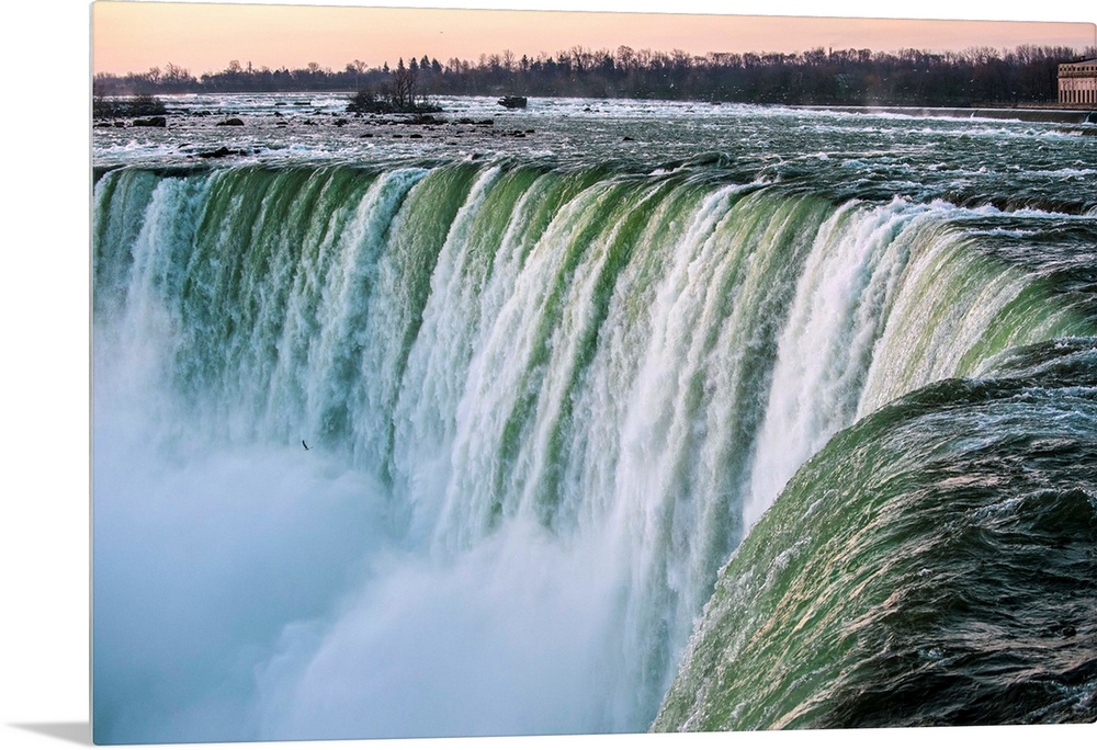 Water cascades down at Horseshoe Falls while dramatic mist ascents to meet the rising sun.