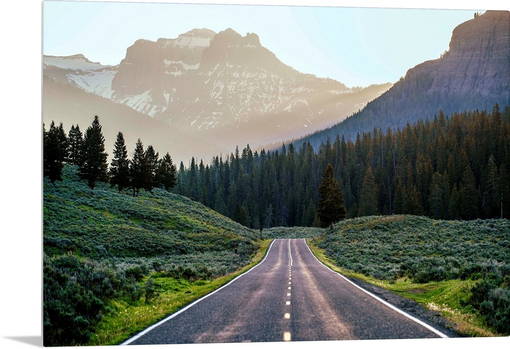 Horizontal image of a road heading to the mountains at Yellowstone National Park.