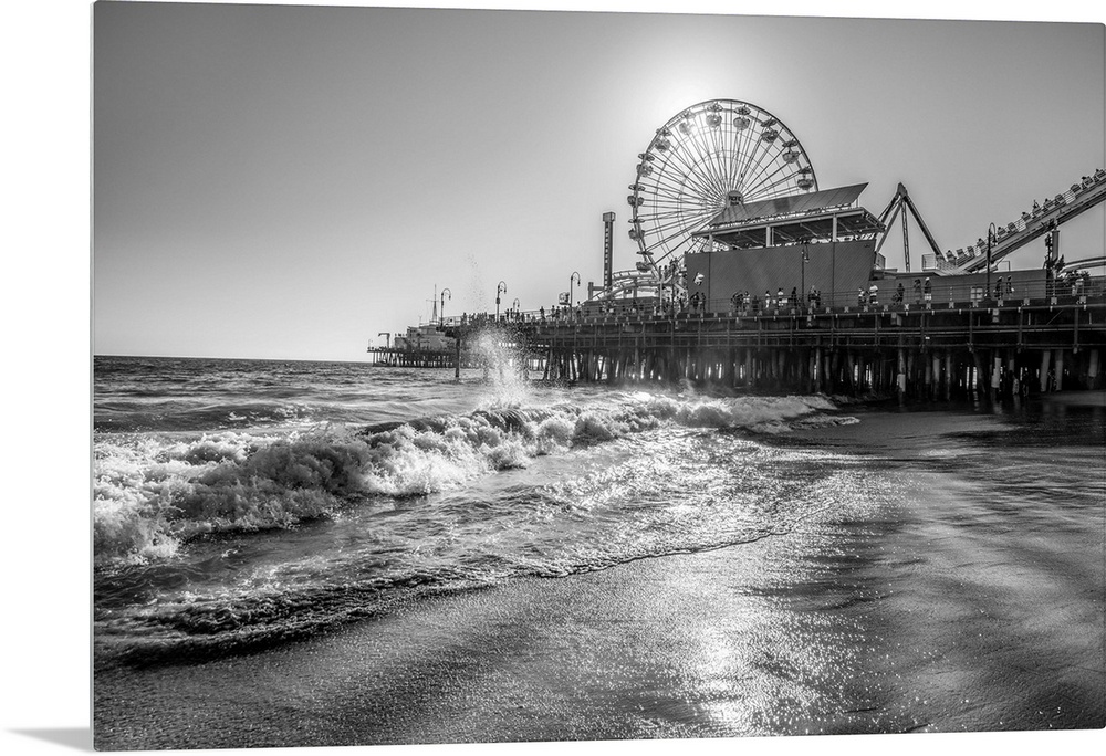 Photograph of the Santa Monica Pier in Los Angeles, California, with the sun setting right behind the Ferris Wheel.