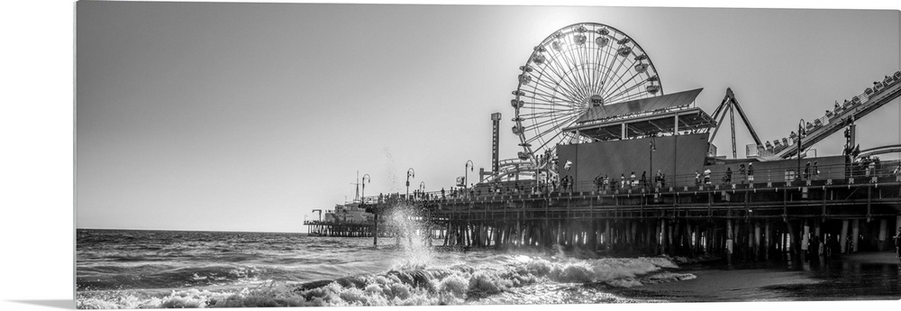 Panoramic photograph of the Santa Monica Pier in Los Angeles, California, with the sun setting right behind the Ferris Wheel.