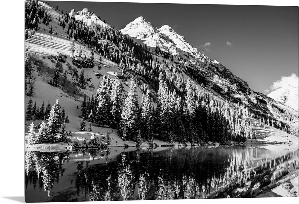 Summer snow on pine trees and the mountain side at the edge of Maroon Lake in the Maroon Bells, Aspen, Colorado.