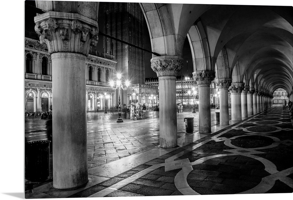 Photograph of the view from underneath arches at night in St. Mark's Square, Venice.